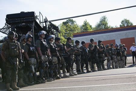 Riot police stand guard while demonstrators protest the shooting death of teenager Michael Brown, in Ferguson, Missouri August 13, 2014. REUTERS/Mario Anzuoni