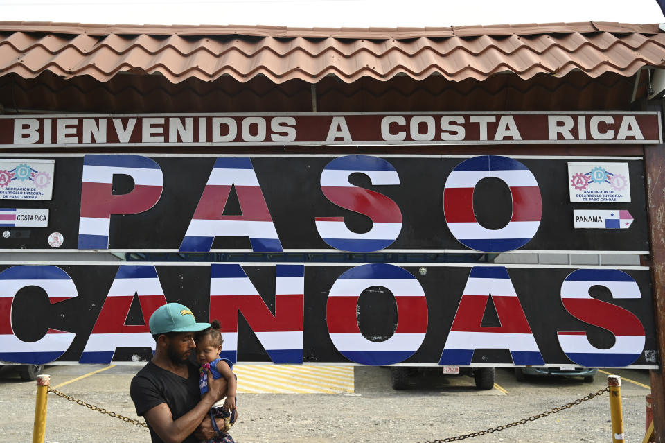 A migrant from Venezuela and his daughter wait for transportation in order to continue on their way north to Nicaragua and hopefully to the Mexico-United States border, in Paso Canoas, Costa Rica, Monday, Oct. 16, 2023. Panama and Costa Rica launched a plan to quickly bus thousands of migrants through Panama to the Costa Rican border, as the countries continue to grapple with the increasing number of migrants. (AP Photo/Carlos Gonzalez)