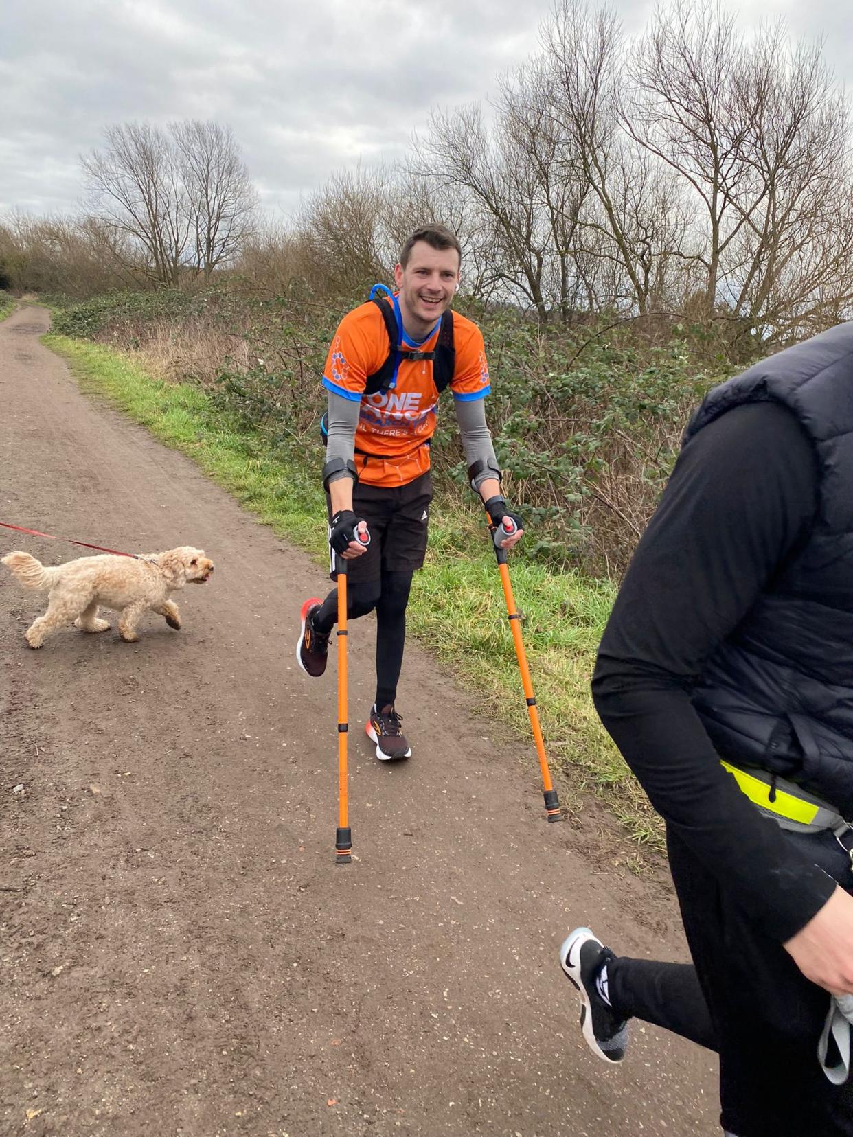 Man walking with crutches and smiling at the camera 