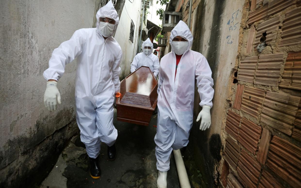 Workers of the Funeral SOS carry a coffin in Manaus