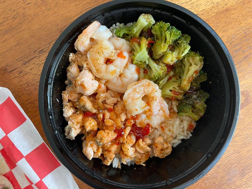 The salmon bowl offers fresh salmon and shrimp with broccoli, coated in sweet chili sauce and garlic butter.