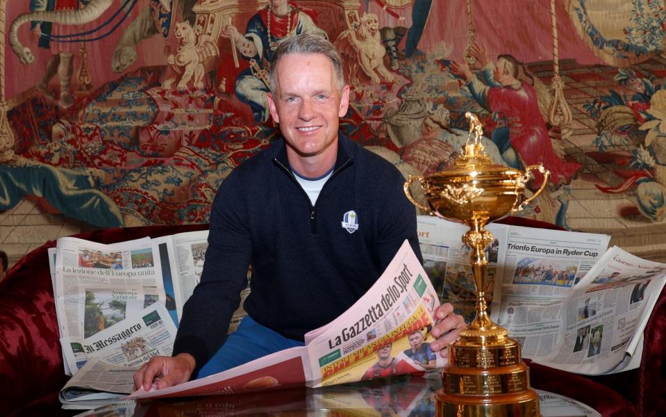 Europe's Ryder Cup captain Luke Donald enjoys the morning newspapers at his Rome hotel – alongside the trophy – the day after his victory