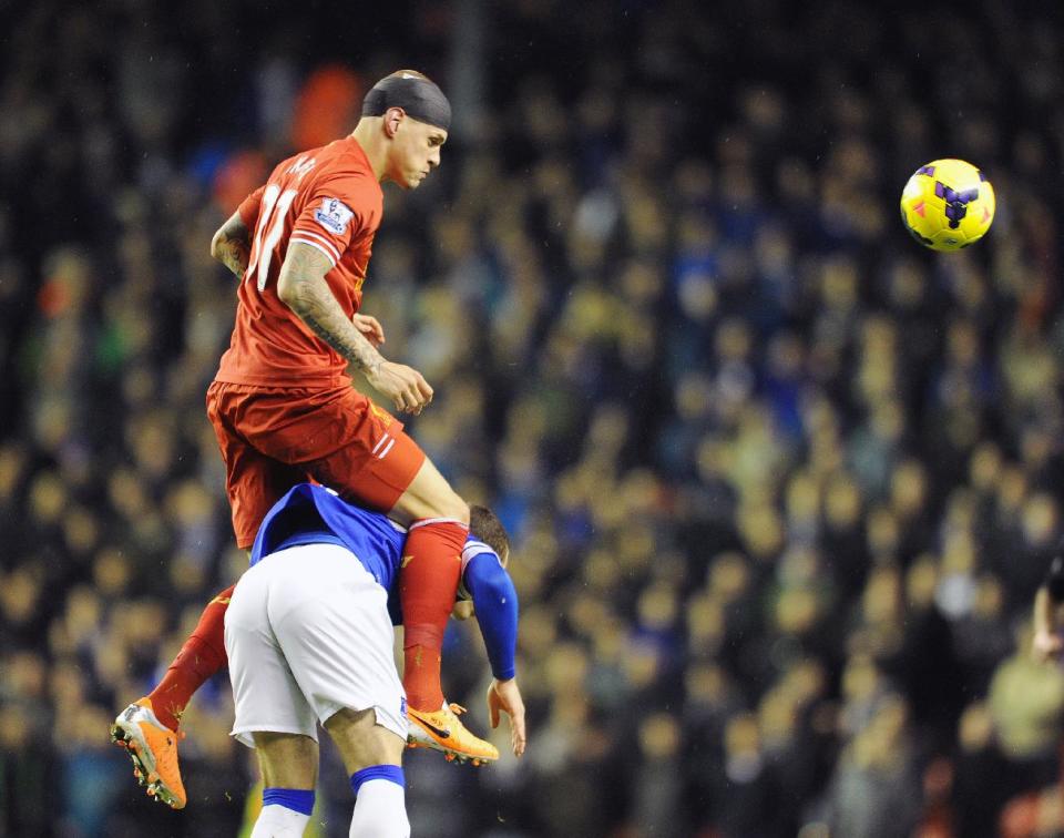 Liverpool's Martin Skrtel top, and Everton's Ross Barkley battle for the ball during their English Premier League soccer match at Anfield in Liverpool, England, Tuesday Jan. 28, 2014. (AP Photo/Clint Hughes)