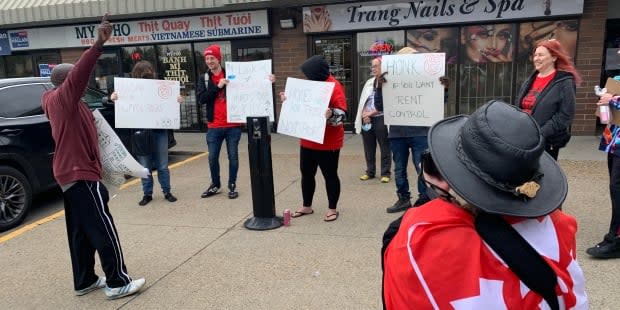 'Honk If You Want Rent Control.' Residents protest in front of the Conservative campaign office in east Calgary. (Elise Stolte/CBC - image credit)