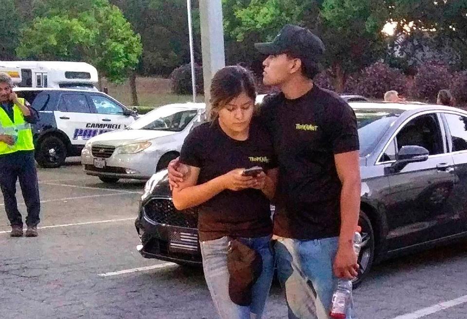 A young couple embrace at a parking lot after a shooting at the Gilroy Garlic Festival on July 28, 2019.