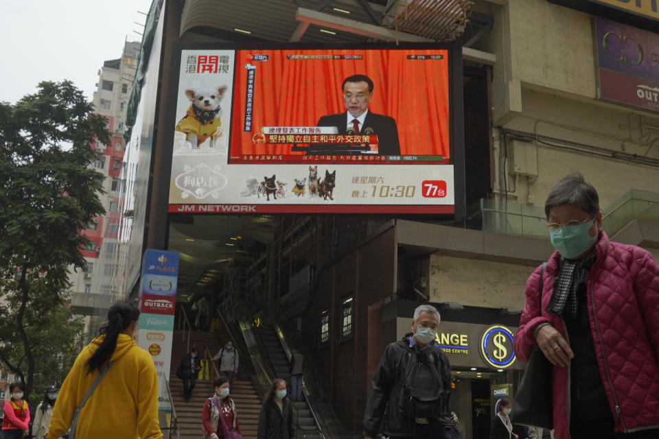 A TV screen broadcasts the news of the opening session of China's National People's Congress (NPC), in Hong Kong, Friday, March 5, 2021. A senior Chinese official says the largely pro-Beijing committee that currently elects the Hong Kong's leader will also elect some members of the city's legislature, as part of Beijing's planned revamp of Hong Kong's electoral system. (AP Photo/Kin Cheung)