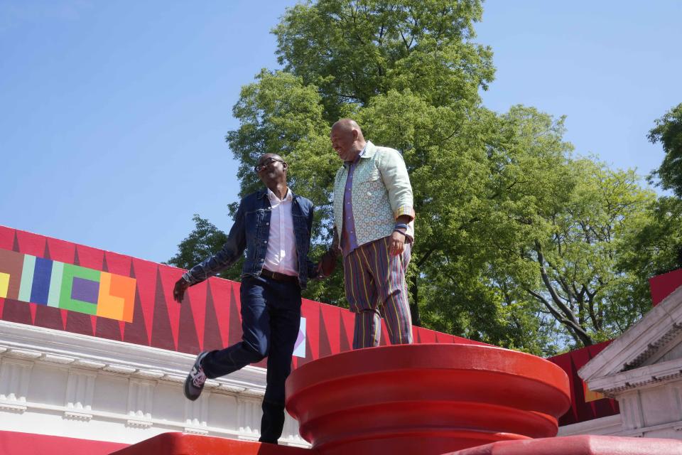 Artist Jeffrey Gibson, right, poses with artist Mark Bradford at the U.S. pavilion during the media open day at the 60th Biennale of Arts in Venice, Italy, Tuesday, April 16, 2024. A Mississippi Choctaw of Cherokee descent, Gibson is the first Native American to represent the United States solo at the Venice Biennale, the world’s oldest contemporary art show. Gibson mixes Western modernism and Native American craft in his vibrantly hued paintings and sculptures. (AP Photo/Luca Bruno)