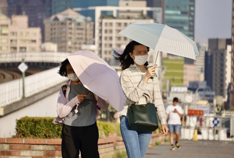 南台灣飆高溫  高雄民眾出遊防曬 中央氣象署17日下午針對南高屏等5縣市發布高溫資 訊，其中高雄市為橙色燈號。圖為高雄市鹽埕區午後 出遊民眾撐傘遮擋豔陽。 中央社記者董俊志攝  113年4月17日 