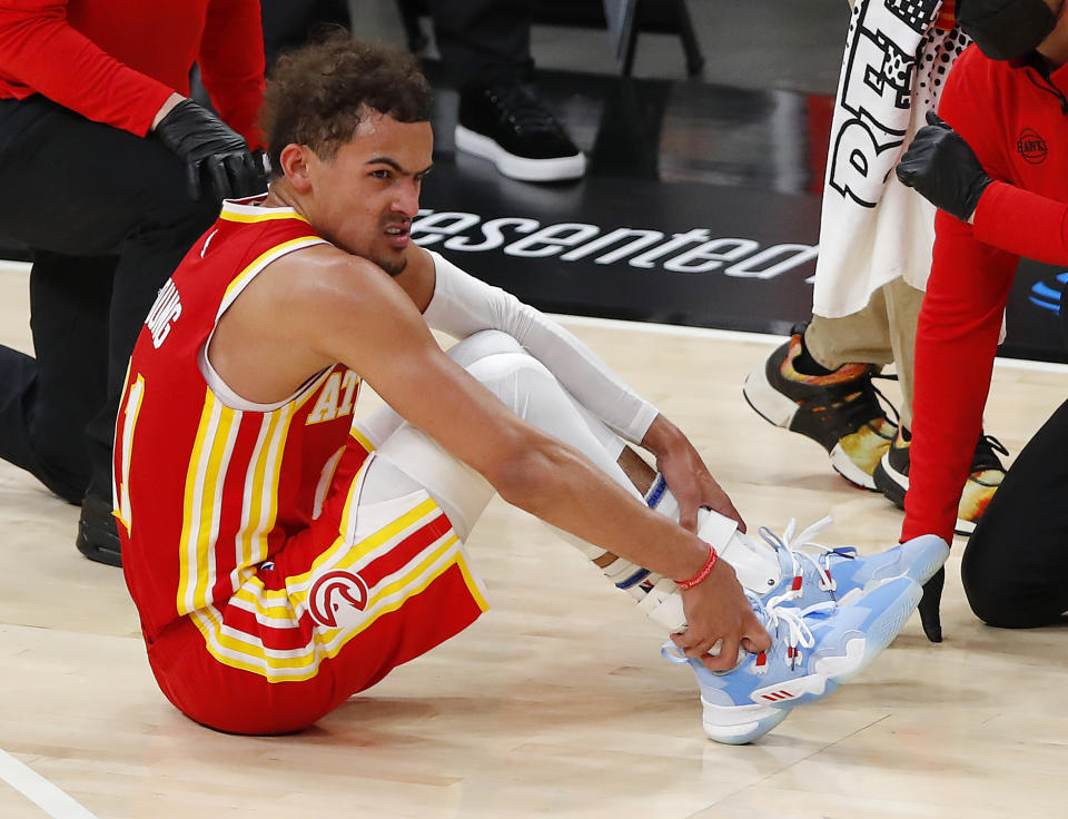 ATLANTA, GEORGIA - JUNE 27: Trae Young #11 of the Atlanta Hawks holds his ankle after an injury during the second half in game three of the Eastern Conference Finals against the Milwaukee Bucks at State Farm Arena on June 27, 2021 in Atlanta, Georgia. NOTE TO USER: User expressly acknowledges and agrees that, by downloading and or using this photograph, User is consenting to the terms and conditions of the Getty Images License Agreement. (Photo by Todd Kirkland/Getty Images)