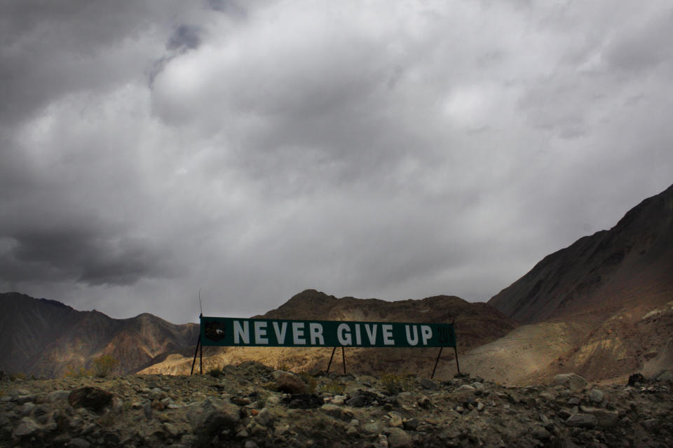 In this Sept. 14, 2017, file photo, a banner erected by the Indian army stands near Pangong Tso lake near the India-China border in India's Ladakh area. India’s defense minister said Thursday, Sept. 17, 2020, the country faces challenges in its border dispute with China and urged Beijing to sincerely implement an understanding they reached previously to completely disengage forces in the Ladakh region. Rajnath Singh said in a statement in the upper house of Parliament that China has amassed troops and armaments in Ladakh in violation of bilateral agreements reached in 1990s and it was creating friction by trying unilaterally to alter the status quo in the region through aggressive postures. (AP Photo/Manish Swarup, File)