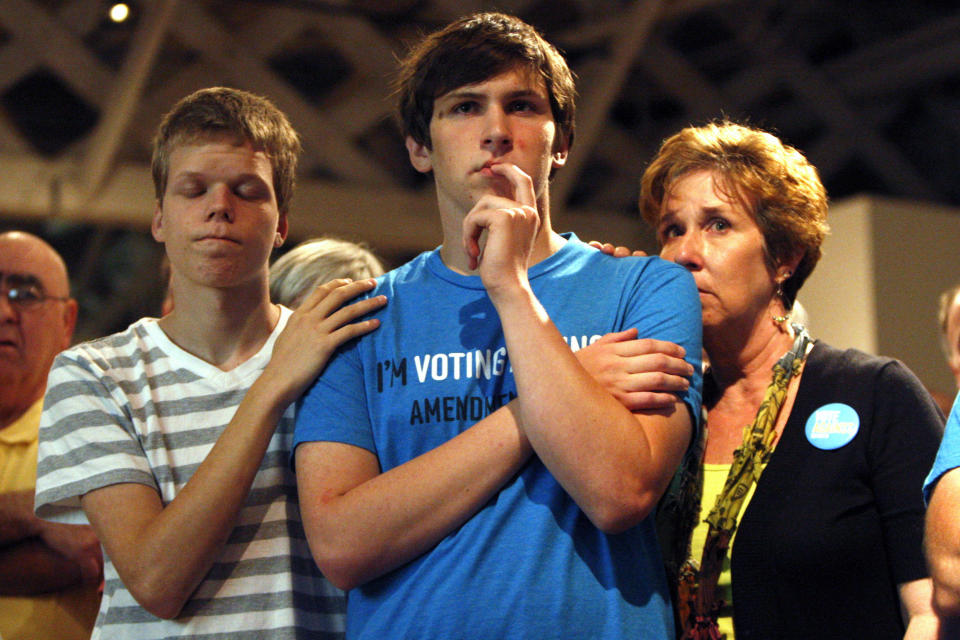 FILE - Seth Keel, center, is consoled by his boyfriend, Ian Chambers, left, and his mother Jill Hinton, during a concession speech at an Amendment One opposition party in downtown Raleigh, N.C., on Tuesday, May 8, 2012. North Carolina voters approved the constitutional amendment Tuesday defining marriage solely as a union between a man and a woman, becoming the latest state to effectively stop same-sex marriages. (Travis Long/The News & Observer via AP, File)