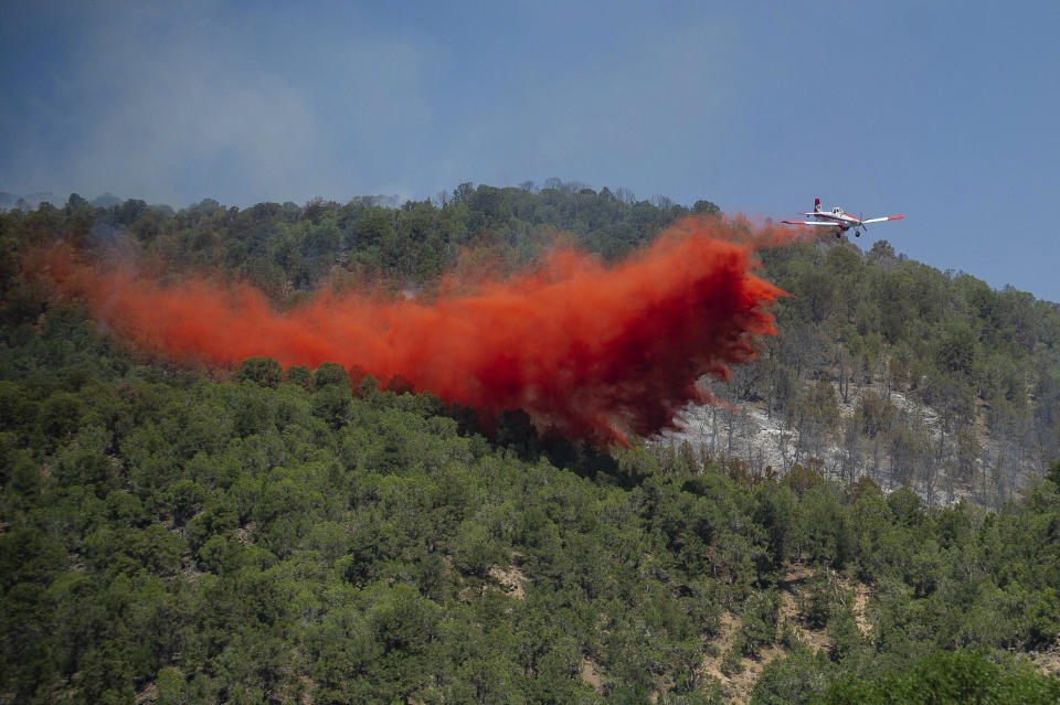 FILE - A plane drops fire retardant near the Lake Christine wildfire on July 4, 2018, in Basalt, Colo. A federal judge said Friday, May 26, 2023, that chemical retardant dropped on wildfires by the U.S. Forest Service is polluting streams in western states in violation of federal law, but said it can keep being use to fight fires. (Anna Stonehouse/The Aspen Times via AP, File)