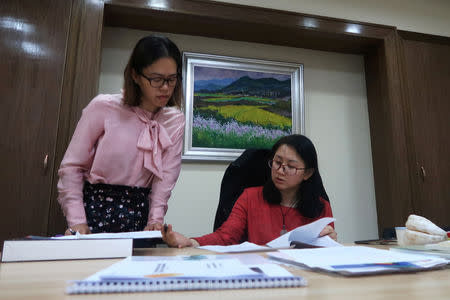Liu Yajing (R), director of Dafen's management office, talks to her colleague at her office in Dafen Oil Painting Village in Shenzhen, Guangdong province, China December 6, 2018. REUTERS/Thomas Suen/Files