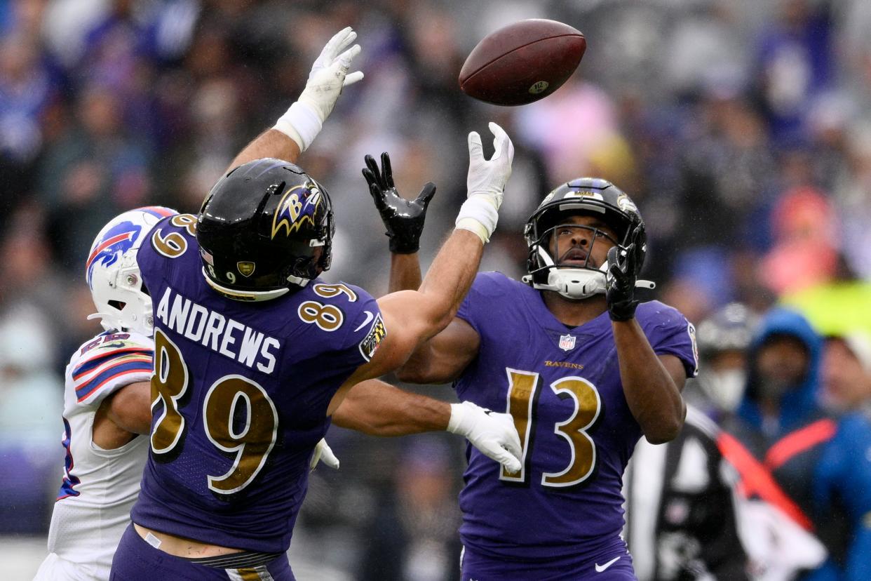 Baltimore Ravens wide receiver Devin Duvernay (13) makes a catch as a pass is deflected into the air in the first half of an NFL football game between the Ravens and the Buffalo Bills Sunday, Oct. 2, 2022, in Baltimore. Also reaching for the ball is Ravens tight end Mark Andrews (89). (AP Photo/Nick Wass)