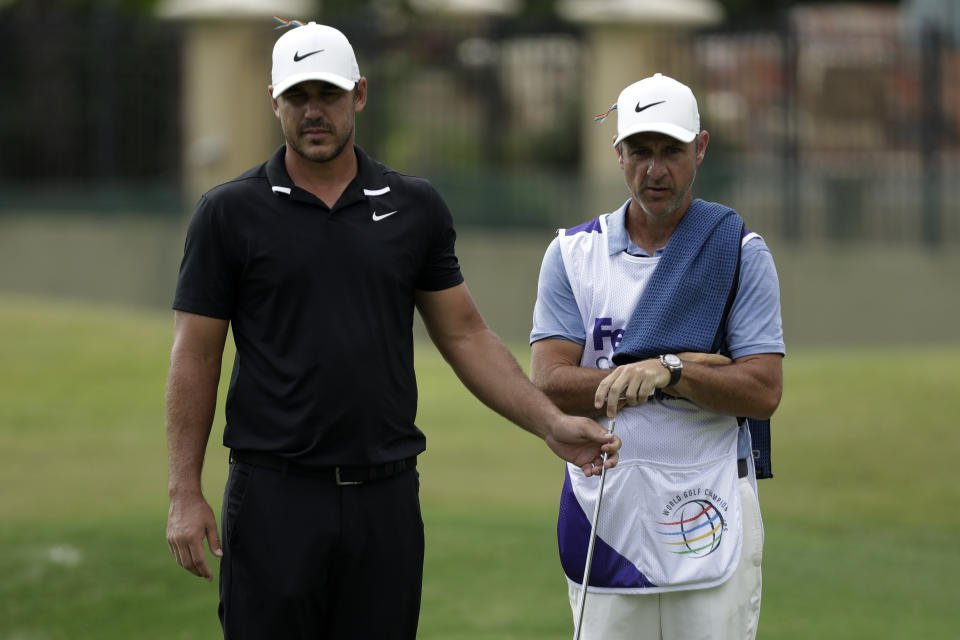 Brooks Koepka looks over a putt with his caddie, Ricky Elliott on the 16th hole during the second round of the World Golf Championship-FedEx St. Jude Invitational Friday, July 31, 2020, in Memphis, Tenn. (AP Photo/Mark Humphrey)