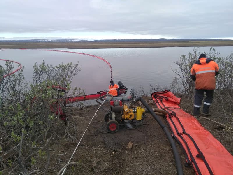 Rescuers work at the site of a huge leak of fuel into the river after an accident at a power plant outside Norilsk