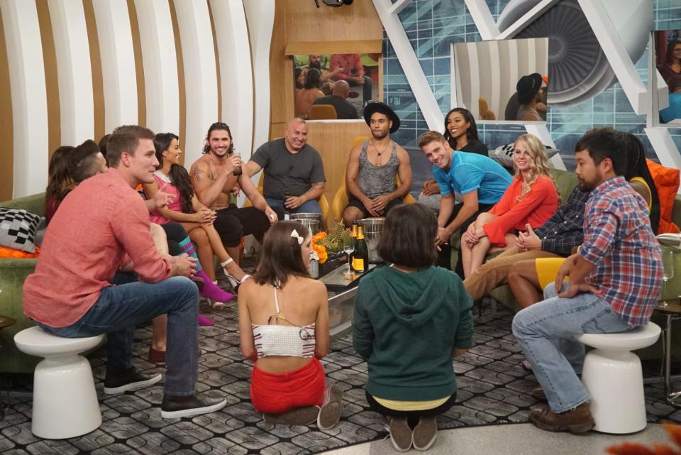 The 2016 "Big Brother" cast sitting in a circle in the living room of the house