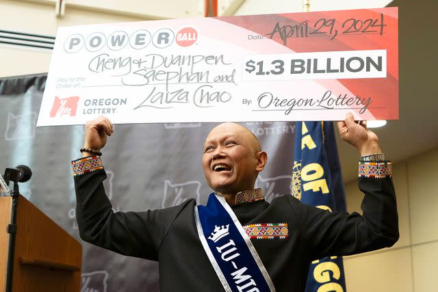 <p>AP Photo/Jenny Kane</p> Cheng "Charlie" Saephan holds display check above his head after speaking during a news conference where it was revealed that he was one of the winners of the $1.3 billion Powerball jackpot at the Oregon Lottery headquarters