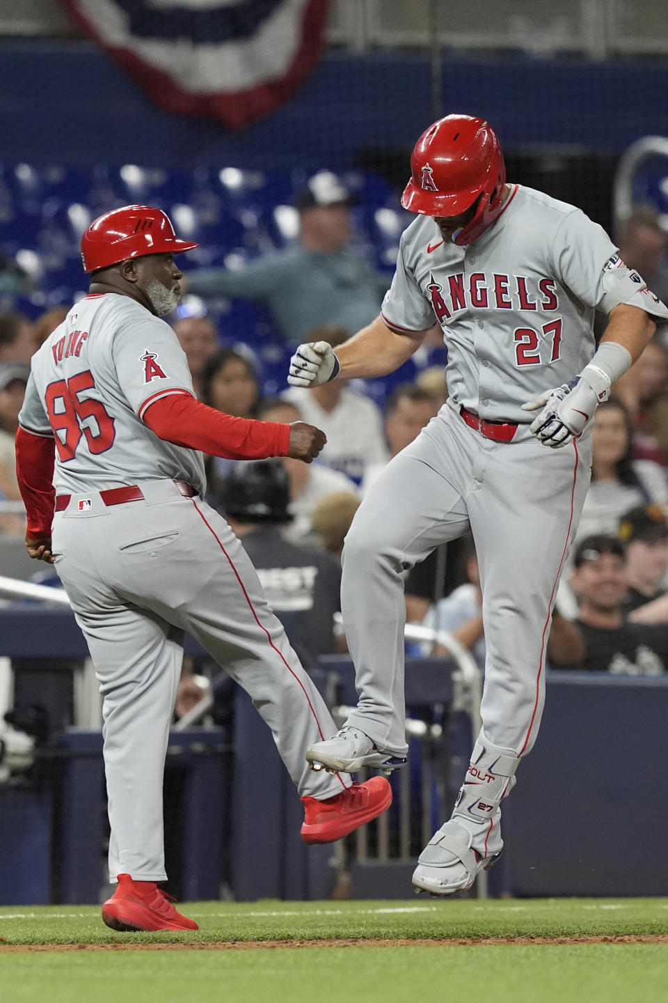 Los Angeles Angels' Mike Trout (27) celebrates his home run with third base coach Eric Young Sr. during the sixth inning of a baseball game against the Miami Marlins, Monday, April 1, 2024, in Miami. (AP Photo/Marta Lavandier)