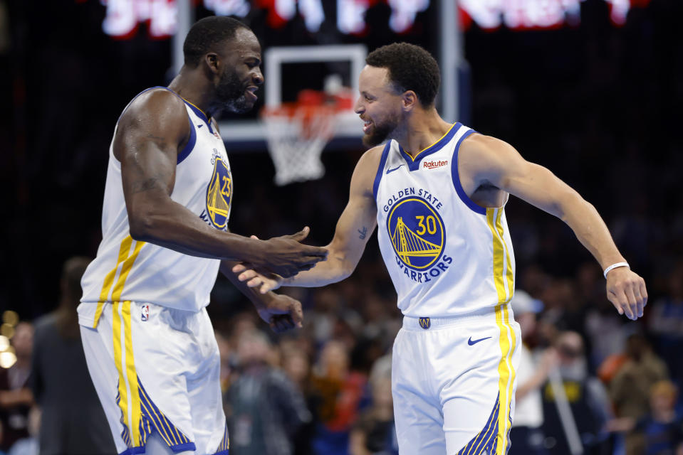 Golden State Warriors forward Draymond Green, left, and guard Stephen Curry celebrate after an offensive goaltending call against Green was overturned in the final second of an NBA in-season tournament basketball game Friday, Nov. 3, 2023, in Oklahoma City. (AP Photo/Nate Billings)