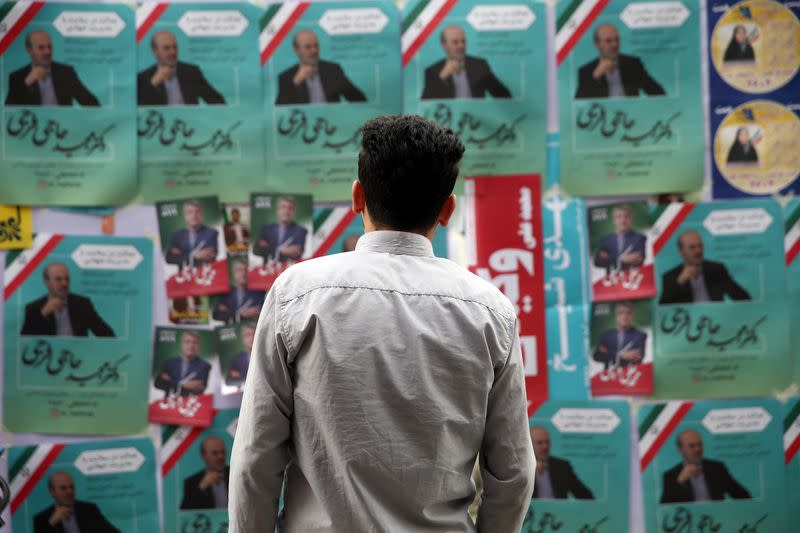 A man looks on parliamentary election campaign posters in Tehran