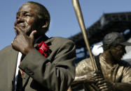 FILE - Minnie Minoso participates in the unveiling of a statue of himself before throwing out the ceremonial first fitch at U.S. Cellular Field before the game between Chicago White Sox and Detroit Tigers, Sunday, Sept. 19, 2004, in Chicago. Minoso has been elected into the Baseball Hall of Fame, Sunday, Dec. 5, 2021. (AP Photo/ Nam Y. Huh, File)