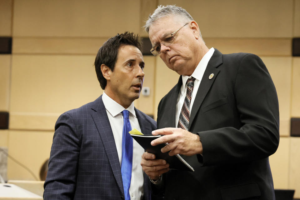 Former Marjory Stoneman Douglas High School School Resource Officer Scot Peterson, right, speaks with his defense lawyer Mark Eiglarsh following a hearing in his case at the Broward County Courthouse in Fort Lauderdale, Fla., on Monday, May 22, 2022. Broward County prosecutors charged Peterson, a former Broward Sheriff's Office deputy, with criminal charges for failing to enter the 1200 Building at the school and confront the shooter, Nikolas Cruz, during a mass shooting at the Parkland high school five years ago. (Amy Beth Bennett/South Florida Sun-Sentinel via AP, Pool)