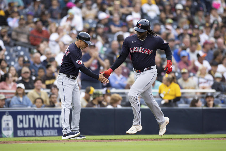 Cleveland Guardians' Josh Bell, right, slaps hands with third base coach Mike Sarbaugh as rounds the bases after hitting a solo home run against the San Diego Padres in the second inning of a baseball game Tuesday, June 13, 2023, in San Diego. (AP Photo/Derrick Tuskan)