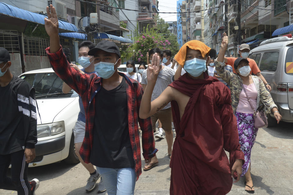 A Buddhist monk joins anti-coup protesters as they flash the three-finger salute of defiance during a demonstration in Yangon, Myanmar on Tuesday April 27, 2021. Demonstrations have continued in many parts of the country since Saturday's meeting of leaders from the Association of Southeast Asian Nations, as have arrests and beatings by security forces despite an apparent agreement by junta leader Senior Gen. Min Aung Hlaing to end the violence. (AP Photo)