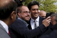 A man takes a selfie with Britain's opposition Labour Party leader Ed Miliband as he leaves after hosting a People's Question Time in Kempston, Britain May 5, 2015. Britain will go to the polls in a national election on May 7. REUTERS/Stefan Wermuth