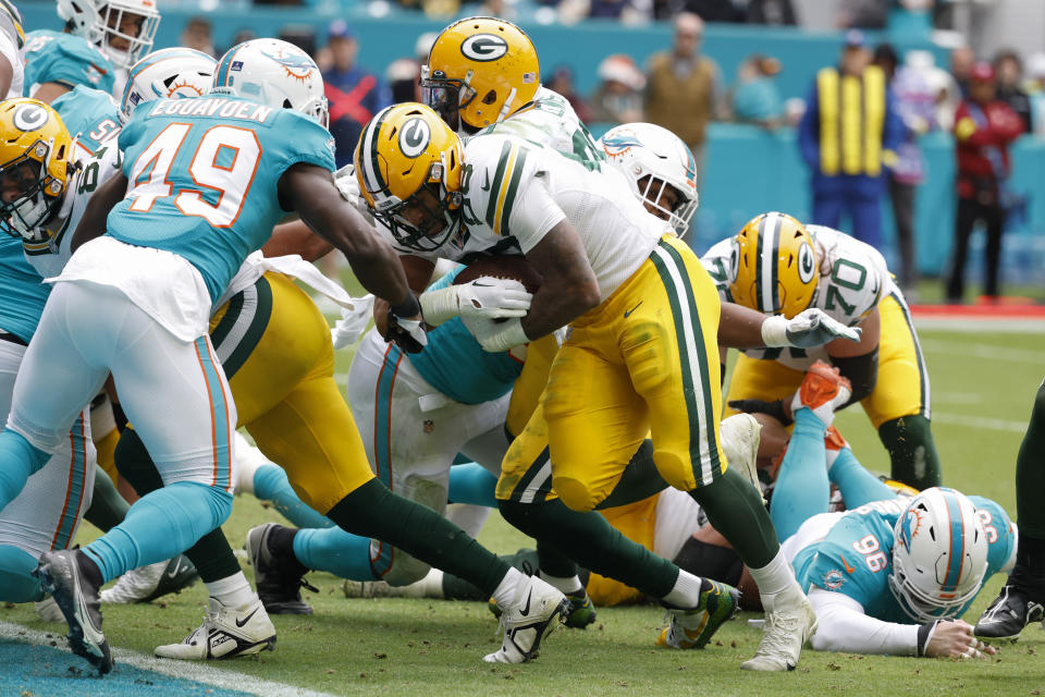 Green Bay Packers running back AJ Dillon (28) rushes one yard to score a touchdown during the second half of an NFL football game against the Miami Dolphins, Sunday, Dec. 25, 2022, in Miami Gardens, Fla. (AP Photo/Rhona Wise)