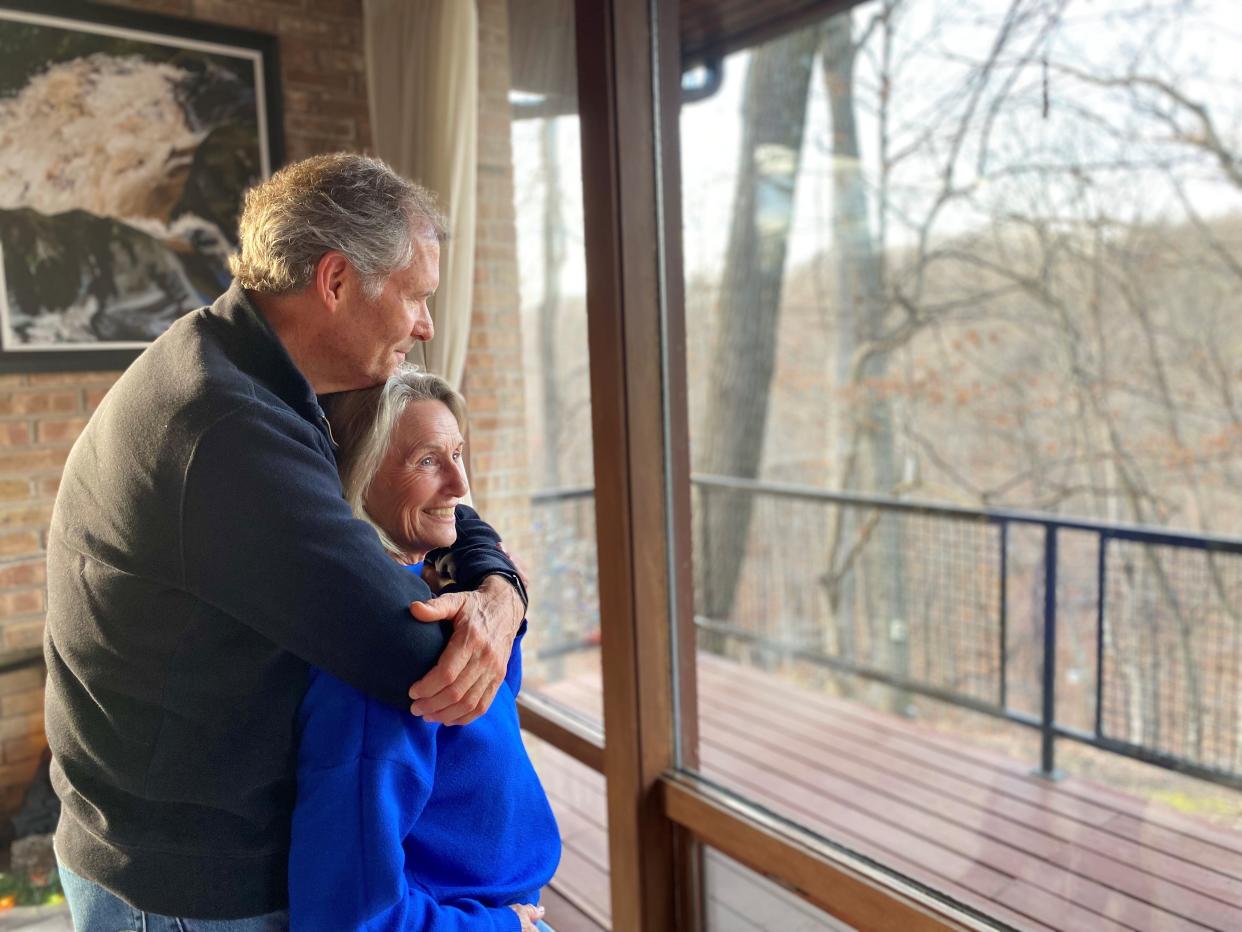 West Lafayette Mayor John Dennis embraces his wife, Mary Dennis, as they stare outside their living room window Friday, Dec. 15, 2023. Mayor Dennis is battling Alzheimer's disease and is retiring after 16 years as mayor.