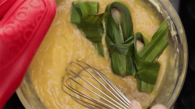 Whisking durian custard batter over boiling water