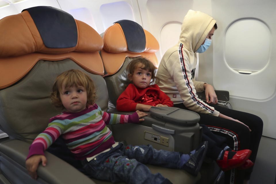 Albanian children sit inside a plane before departing, during an operation to take them back home to Albania from al-Hol, northern Syria, in Beirut, Lebanon, Tuesday, Oct. 27, 2020. The repatriation of four children and a woman related to Albanian nationals who joined Islamic extremist groups in Syria "is a great step" to be followed by more repatriations, Albania's prime minister said Tuesday in Beirut. (AP Photo/Bilal Hussein)