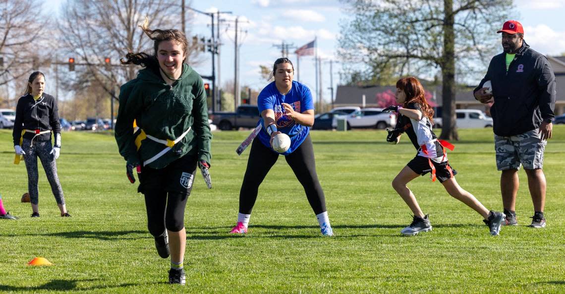 Optimist Youth Football Girls Flag 5’s player Neasjah Ellis, 12, center, hands the ball off to Kennedy Glenn, 11, in a play during practice April 17 at Settlers Park in Meridian. Sarah A. Miller/smiller@idahostatesman.com