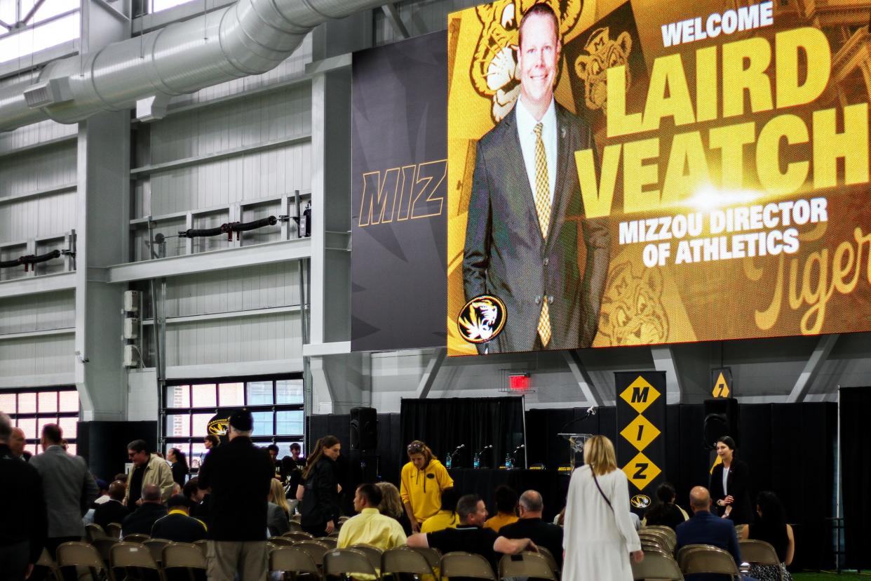 A welcome sign for new Missouri athletic director Laird Veatch is projected above visitors before a press conference at Stephens Indoor Facility on April 26, 2024 in Columbia, Mo.