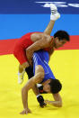 Darkhan Bayakhmetov (blue) of Kazakhstan is thrown by Li Yanyan (red) of China in the Men's Greco-Roman 66kg quarter final bout at the China Agriculture University Gymnasium during Day 5 of the Beijing 2008 Olympic Games on August 13, 2008 in Beijing, China. (Clive Rose/Getty Images)