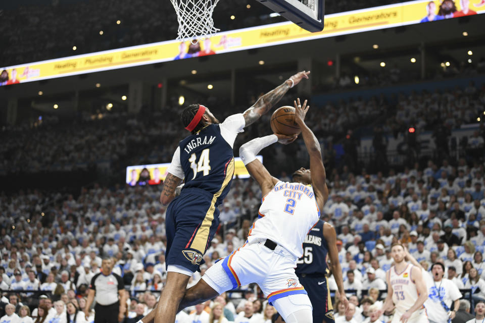 New Orleans Pelicans forward Brandon Ingram (14) tries to block a shot by Oklahoma City Thunder guard Shai Gilgeous-Alexander (2) in the first half of Game 1 of an NBA basketball first-round playoff series, Sunday, April 21, 2024, in Oklahoma City. (AP Photo/Kyle Phillips)