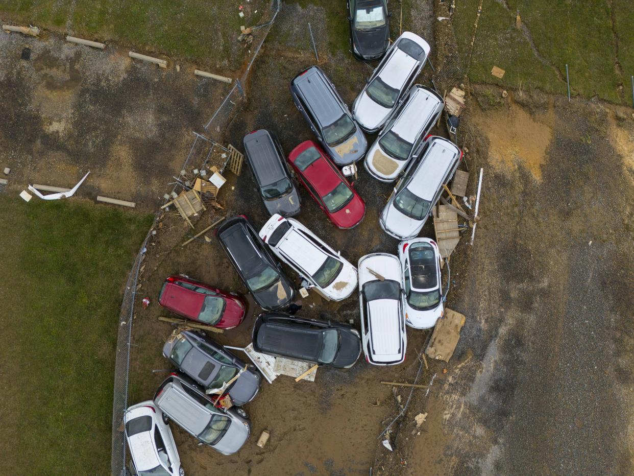 Vehicles and debris that were caught in a flash flood from Hurricane Helene rest on the side of tae road near the Swannanoa River, Tuesday, Oct. 1, 2024, in Swannanoa, N.C. (AP Photo/Mike Stewart)