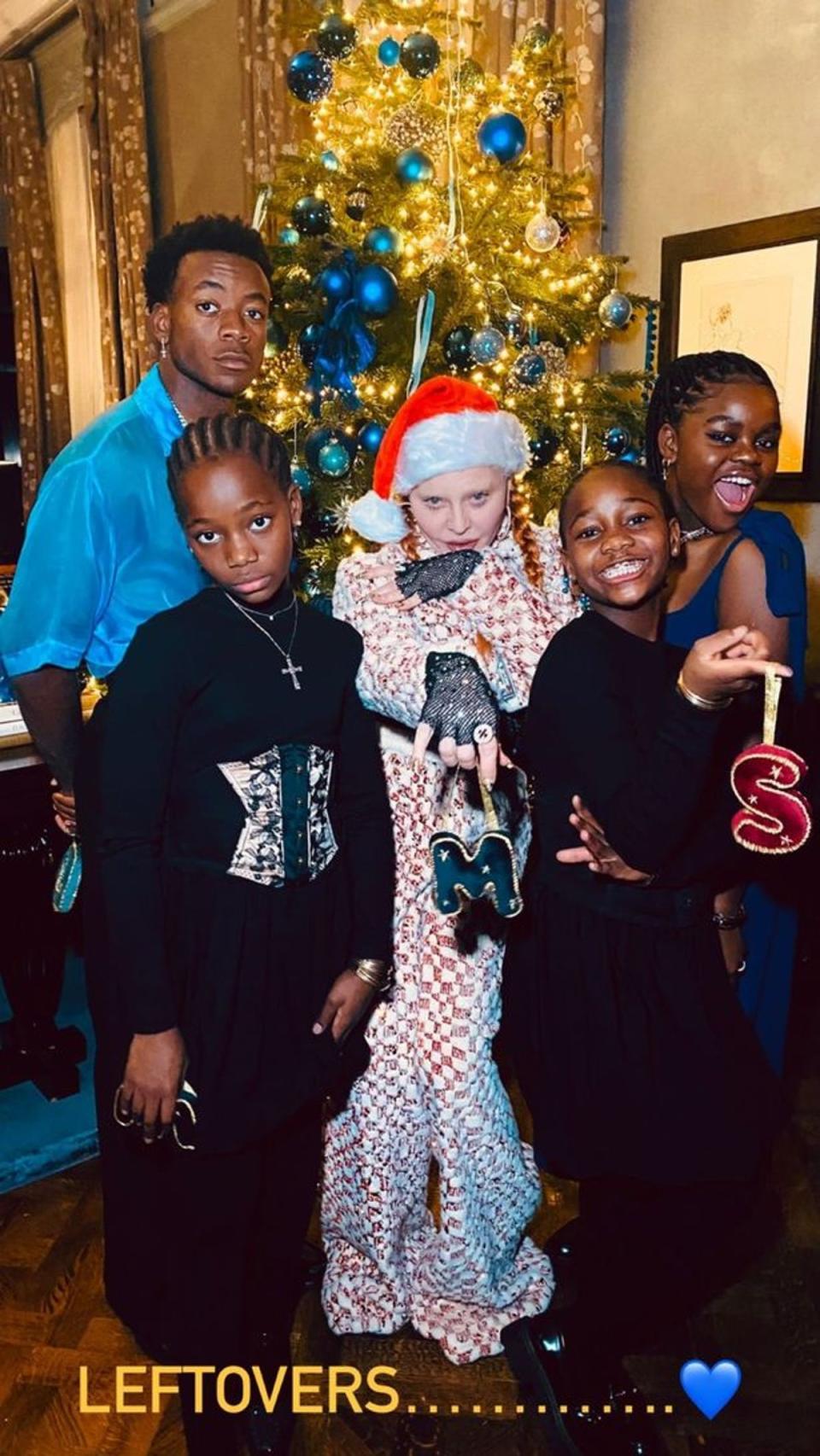 Madonna and her children pose in front of their blue-themed Christmas tree (Instagram)