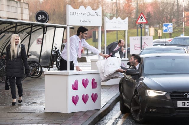 EDITORIAL USE ONLYA woman looks-on as Graig Bieszke from Manchester uses the worldâ€™s first Debenhams Drive Thru, which has been created ahead of Valentineâ€™s Day, to help shoppers pick gifts for their partners at the Trafford Centre in Manchester. PRESS ASSOCIATION Photo. Picture date: Tuesday February 7, 2017. With a choice of pre-selected gifts, from lingerie to aftershave, the pilot experience guarantees shoppers will drive away with a present all without leaving the comfort of their car. Photo credit should read: Anthony Devlin/PA Wire