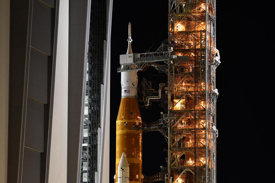 The 322-foot-tall Space Launch System moon rocket slowly moves out of the Vehicle Assembly Building at the Kennedy Space Center for the 4.2-mile-trip to launch pad 39B, setting the stage for blastoff Aug. 29 on the booster's maiden flight. / Credit: William Harwood/CBS News