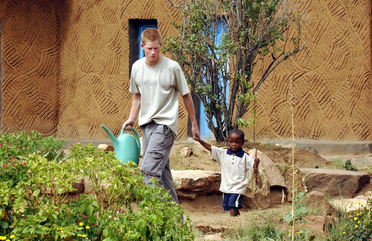 Harry leading young orphan Mutsu Potsane, four, by the hand to plant a peach tree together at the Mants'ase Children's Home near Mohale's Hoek