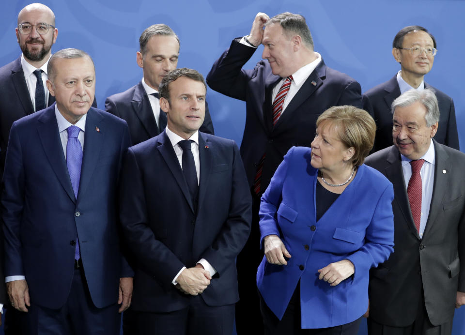 German Chancellor Angela Merkel, front second left, waits for the arrival of leaders prior to a group photo at a conference on Libya at the chancellery in Berlin, Germany, Sunday, Jan. 19, 2020. Front row left to right, Turkish President Recep Tayyip Erdogan, French President Emmanuel Macron, and United Nations Secretary General Antonio Guterres. Back row left to right, European Council President Charles Michel, German Foreign Minister Heiko Maas, U.S. Secretary of State Mike Pompeo and Chinese State Councilor Yang Jiechi. (AP Photo/Michael Sohn)