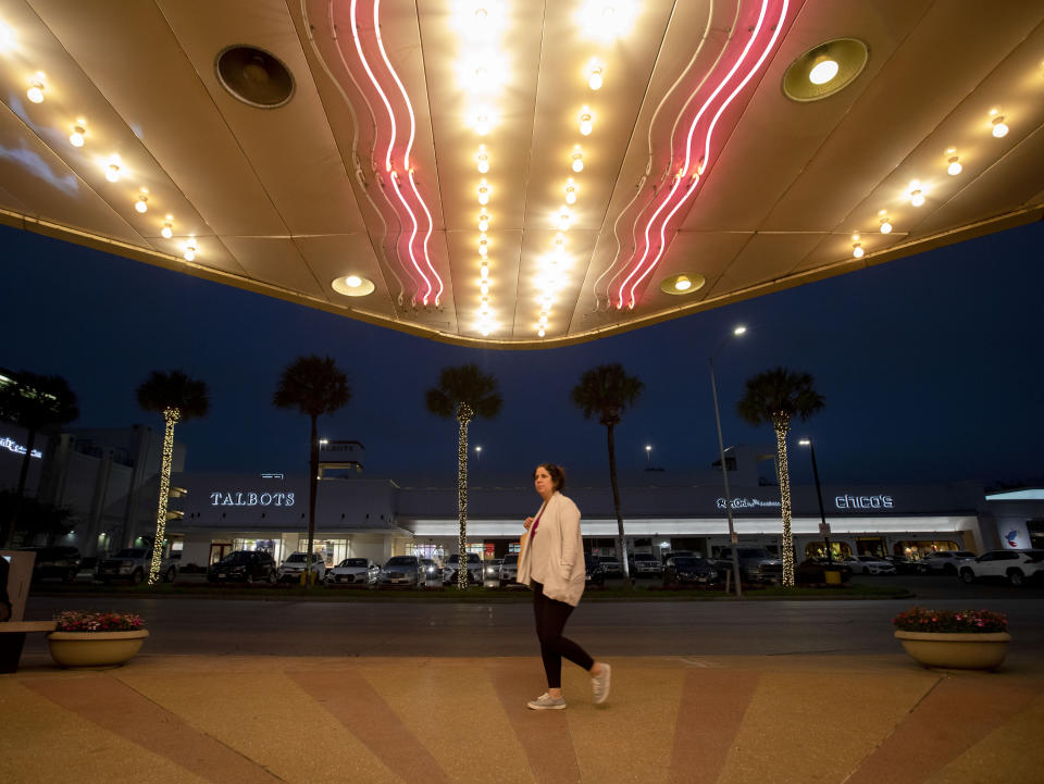 A woman walks past by River Oaks Theatre's neon marquee on the second last day of the theater Wednesday, March 24, 2021, in Houston. The historic theater that director Richard Linklater called his “film school” and that for decades was the place to catch hard-to-find independent and foreign films has closed for good. Like many U.S. movie theaters and other businesses, the River Oaks Theatre was a victim of the coronavirus pandemic.(Yi-Chin Lee/Houston Chronicle via AP)