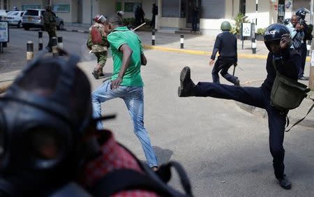 Kenyan policemen beat a protester during clashes in Nairobi, Kenya May 16, 2016. REUTERS/Goran Tomasevic