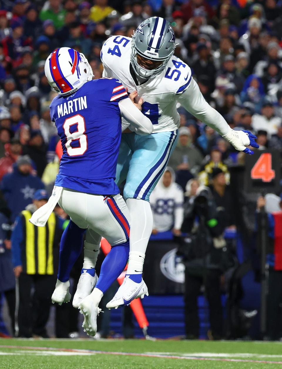 Buffalo Bills punter Sam Martin (8) is hit by Dallas Cowboys defensive end Sam Williams (54) while punting the ball during the second quarter of an NFL football game, Sunday, Dec. 17, 2023, in Orchard Park, N.Y. (AP Photo/Jeffrey T. Barnes)