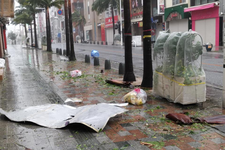 颱風卡努帶來的強風襲擊沖繩縣那霸市，2日市中心街道上散落著碎片。（法新社）