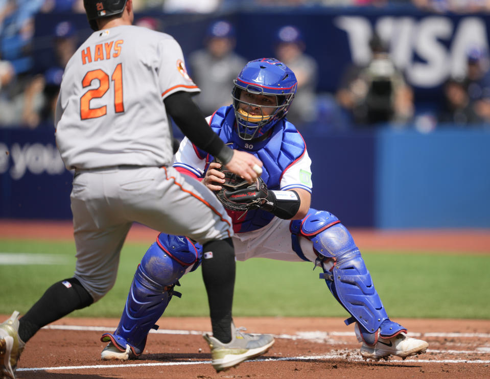 Toronto Blue Jays catcher Alejandro Kirk (30) tags out Baltimore Orioles left fielder Austin Hays (21) at home plate during the second inning of a baseball game in Toronto on Thursday Aug. 3, 2023. (Mark Blinch/The Canadian Press via AP)