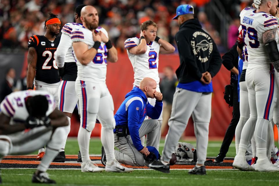Buffalo Bills head coach Sean McDermott takes a knee as safety Damar Hamlin (3) is tended to on the field following a collision in the first quarter of a Week 17 NFL game against the Cincinnati Bengals.